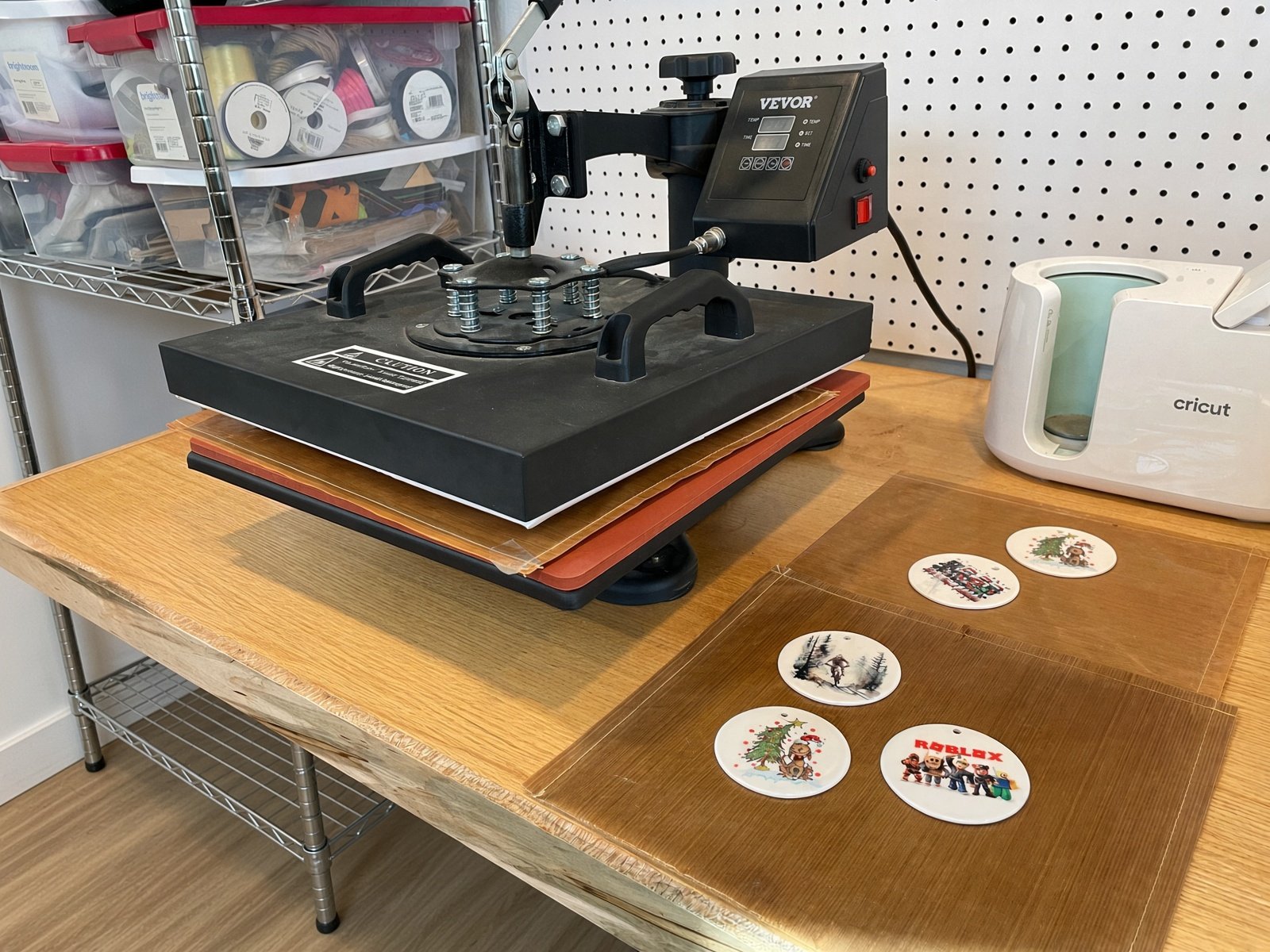 Heat press and ceramic Christmas ornaments on the work table